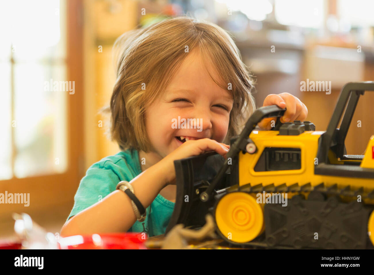 Portrait of Caucasian boy playing with toy bulldozer Stock Photo