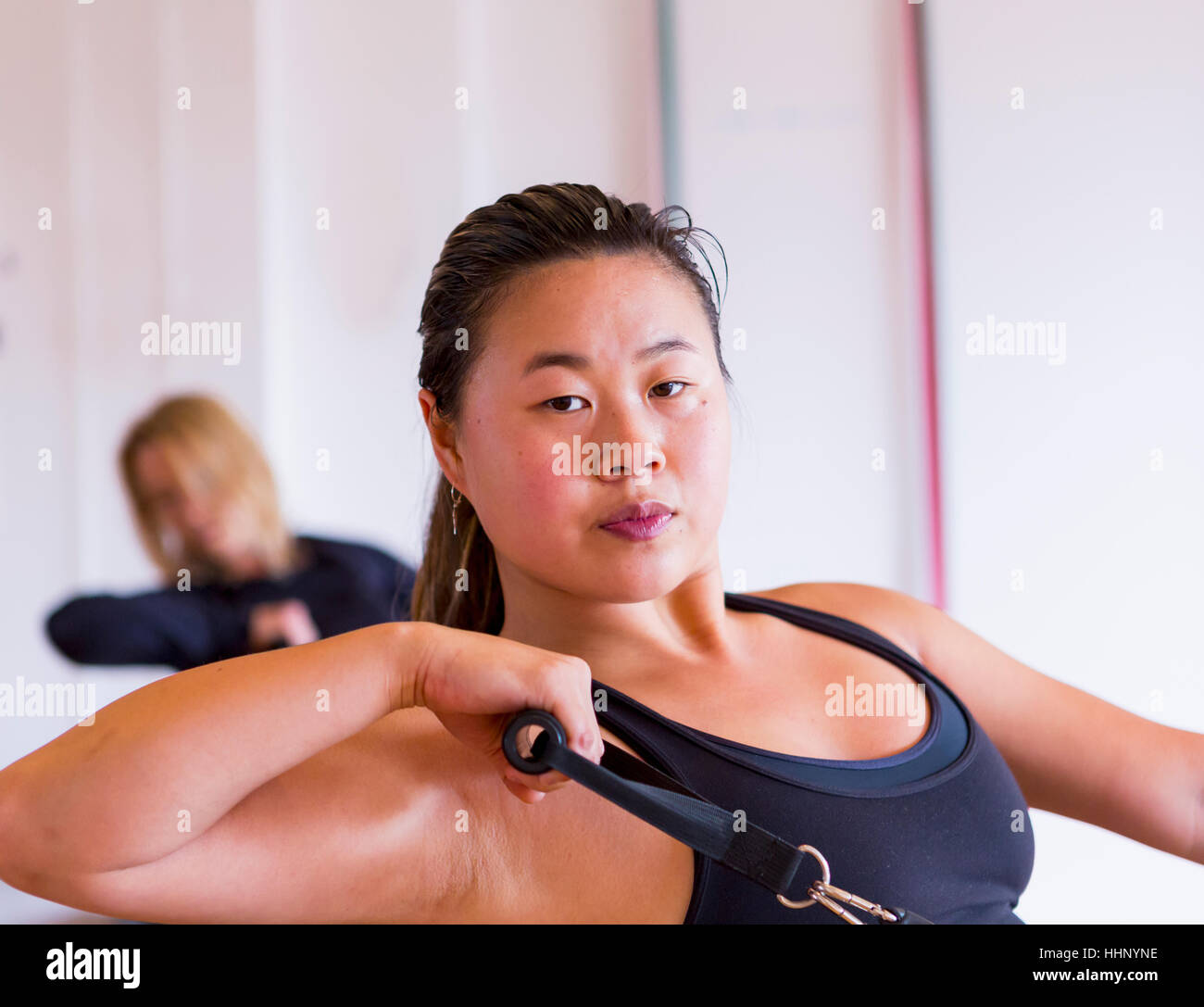Portrait of Asian woman pulling handle in gymnasium Stock Photo