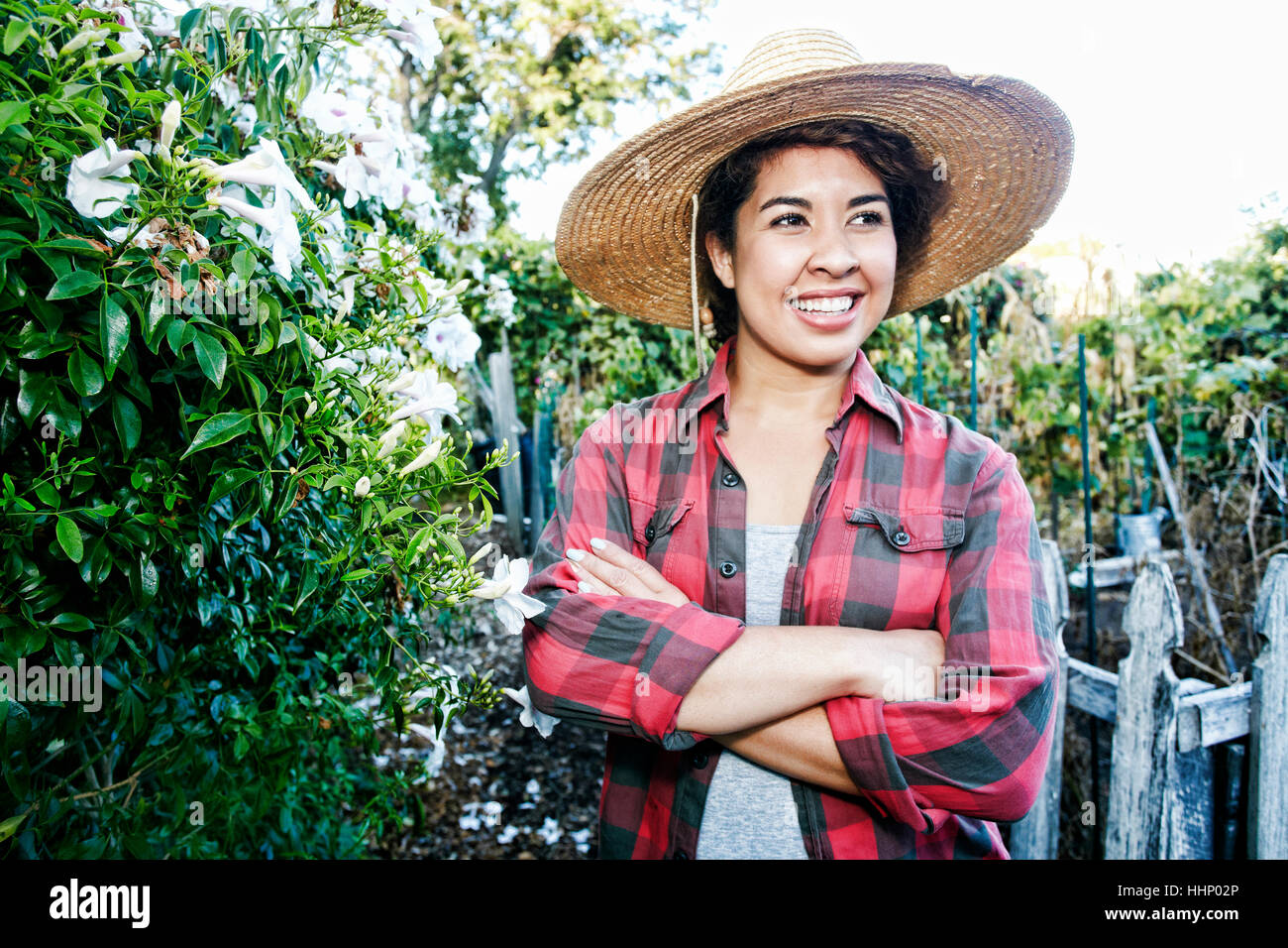 Smiling Mixed Race woman standing in garden Stock Photo