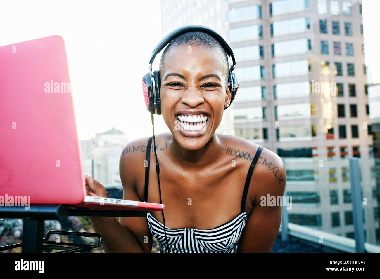 Portrait of Black DJ laughing on urban rooftop Stock Photo