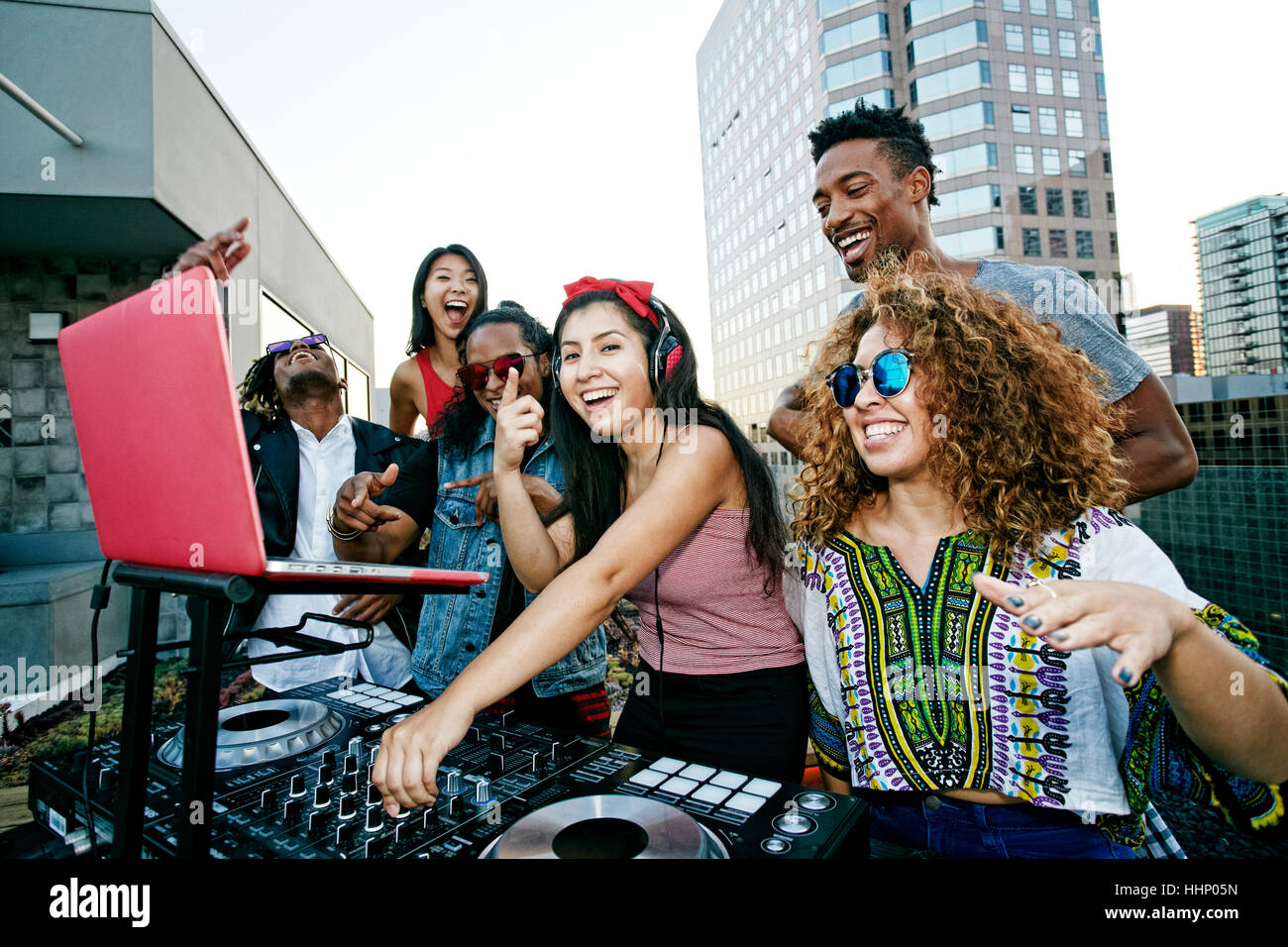 Friends posing with DJ on urban rooftop Stock Photo - Alamy