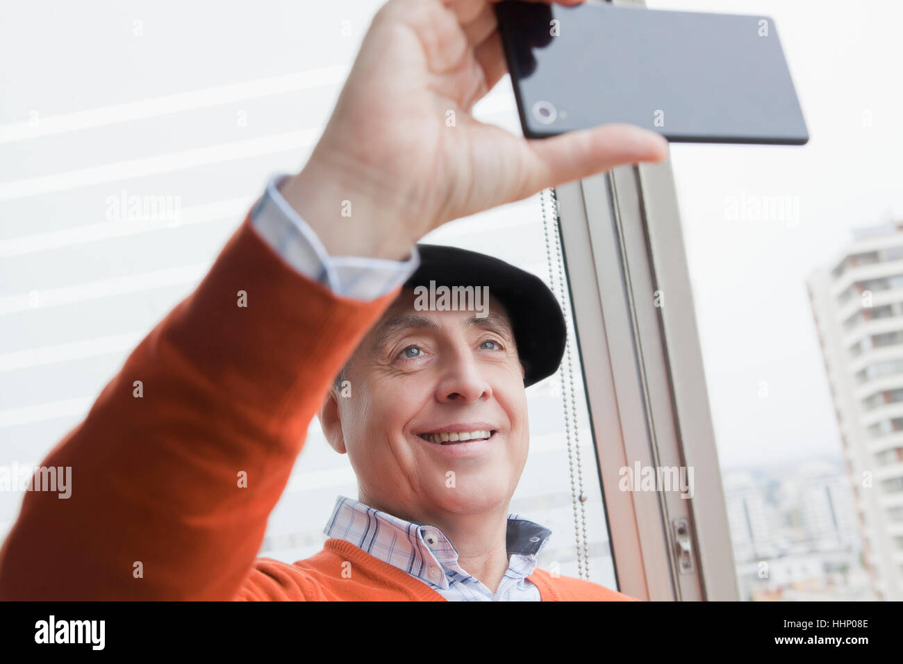 Smiling Hispanic man posing for cell phone selfie Stock Photo