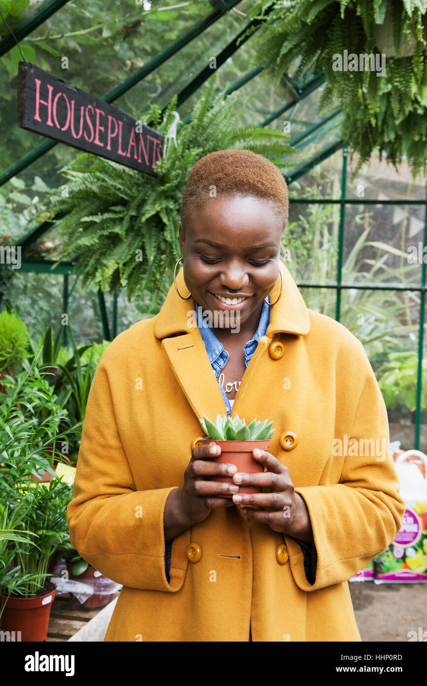 Portrait of smiling Black woman holding potted plant Stock Photo - Alamy