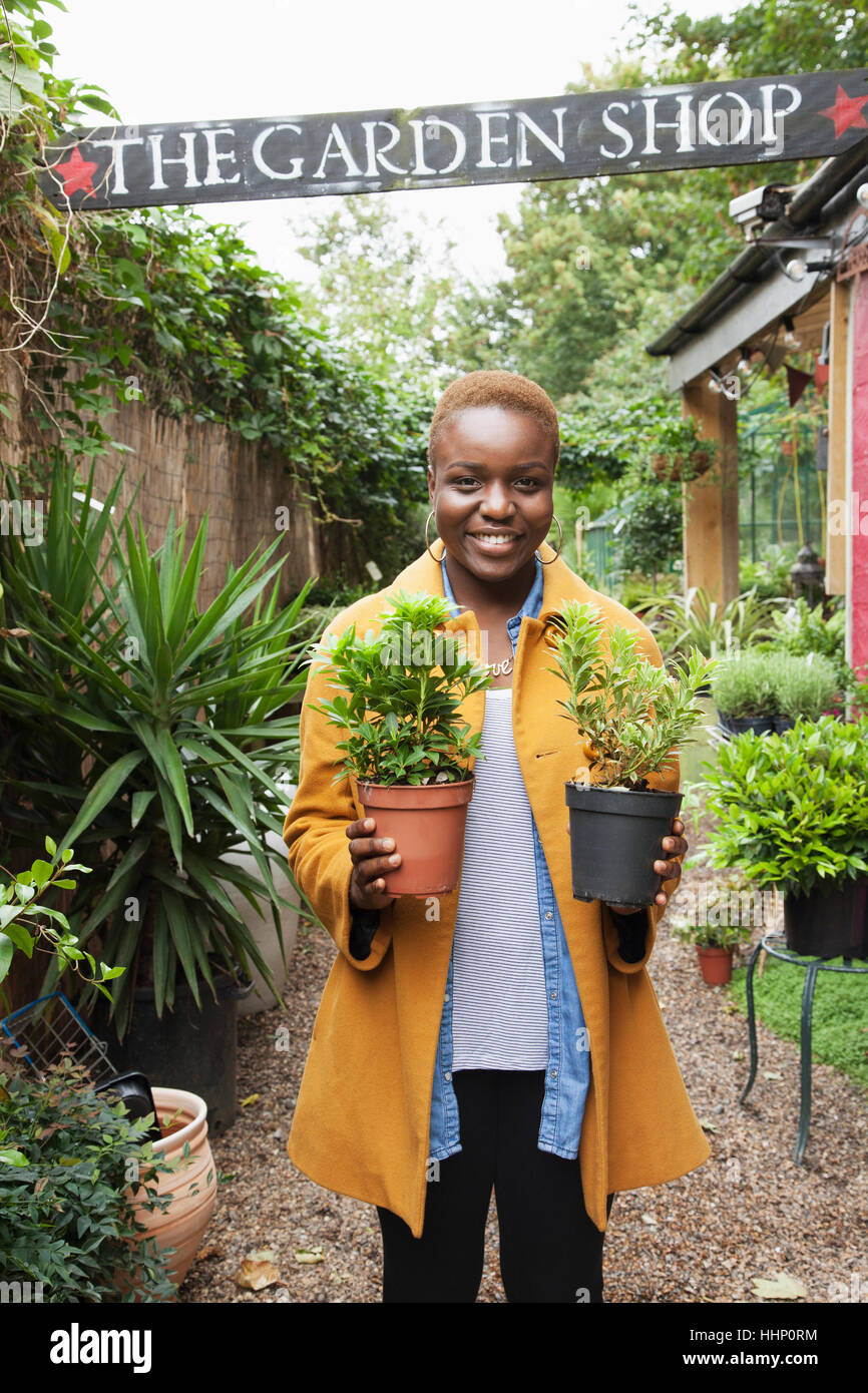 Portrait of smiling Black woman holding potted plants Stock Photo - Alamy