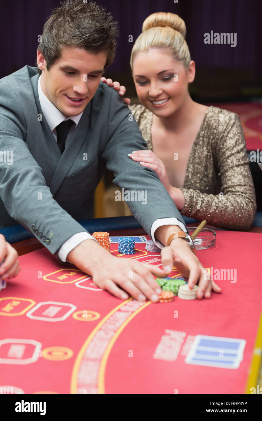 Man winning at poker with woman next to him in casino Stock Photo