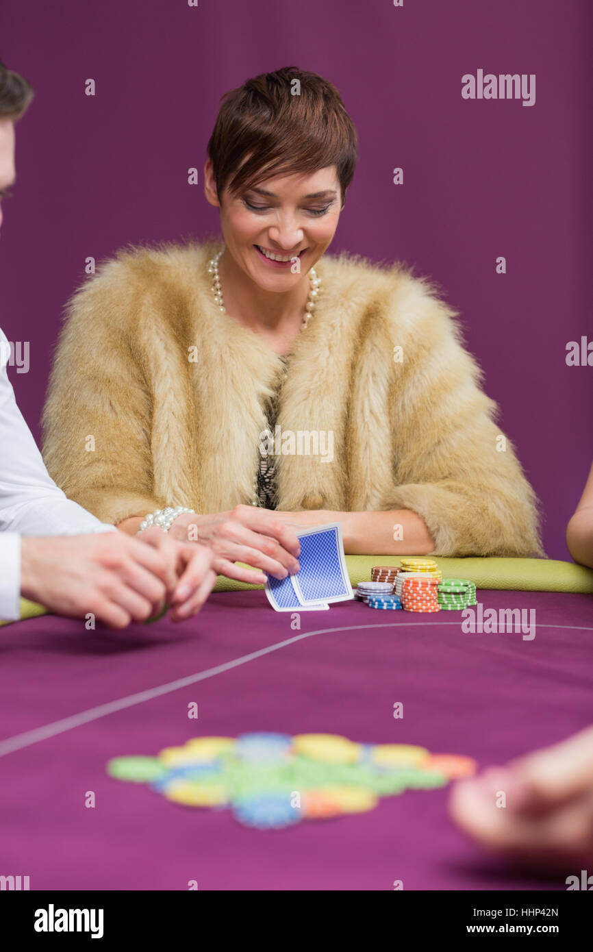 Woman smiling looking at her cards at the casino Stock Photo