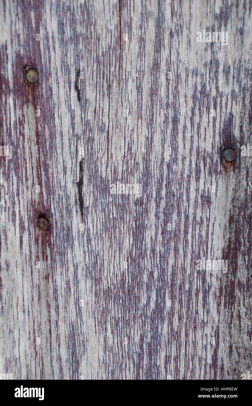 Shows woodgrain and three rusty nail heads and the other paint is blue