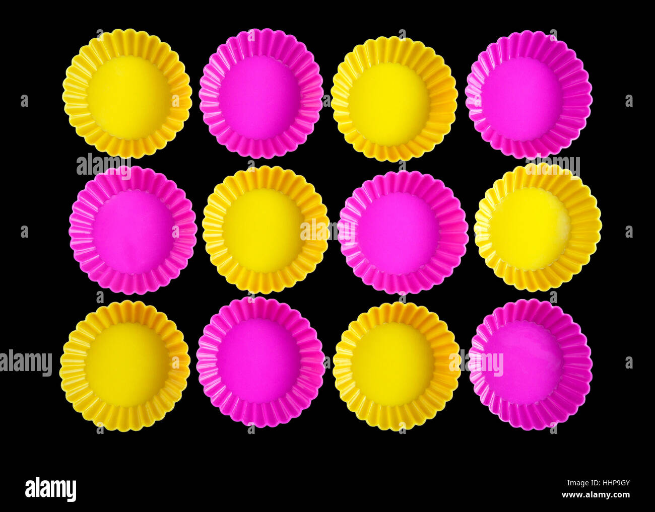Group of yellow and pink rounded objects rotated on black background ...
