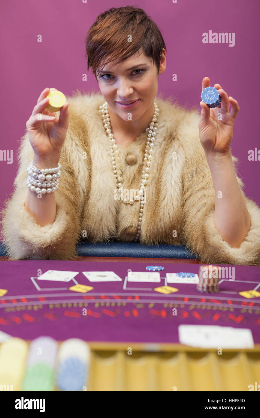 Woman holding up chips at poker game in casino Stock Photo