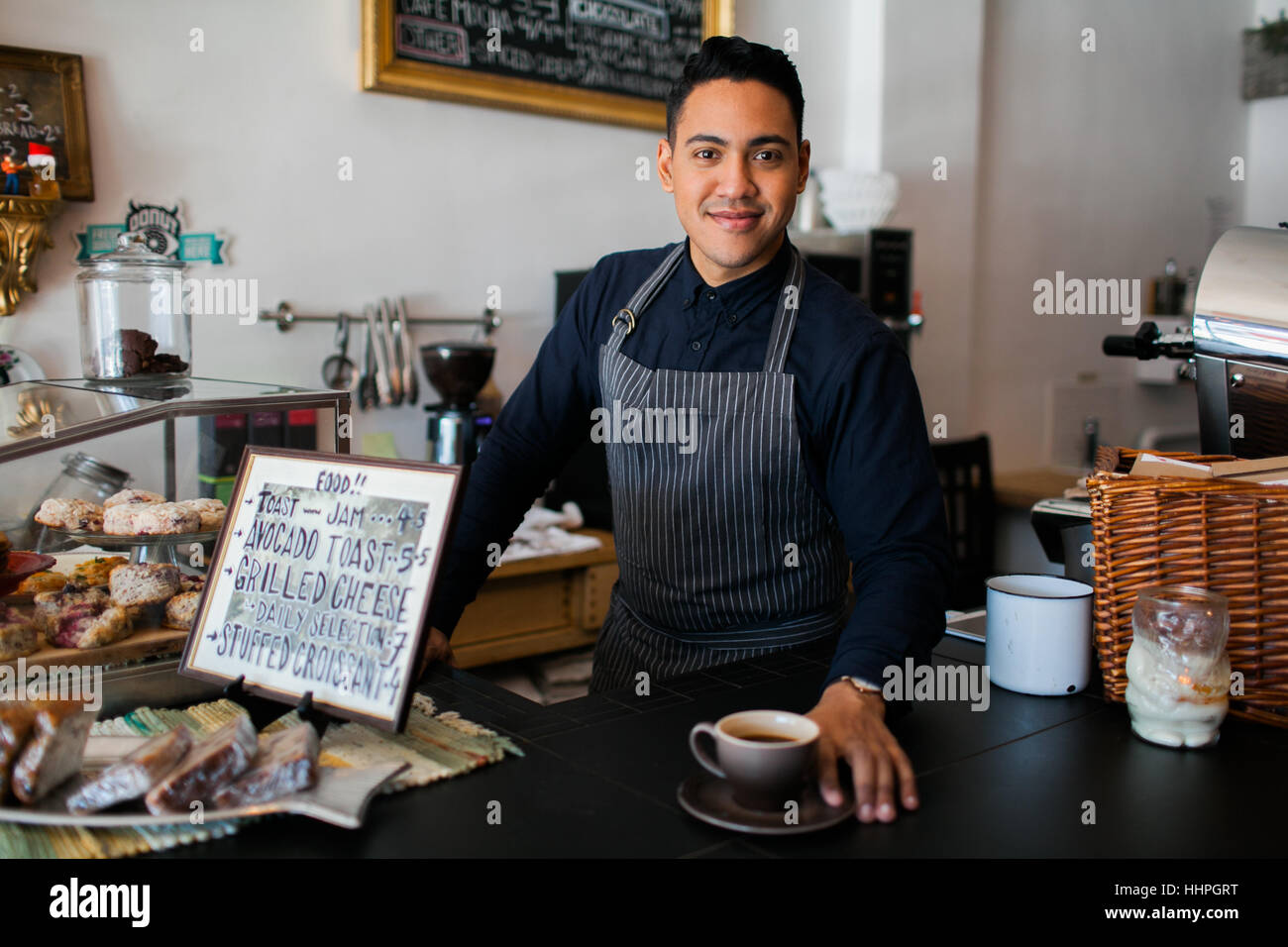 Smiling coffee shop worker serving up a coffee Stock Photo Alamy