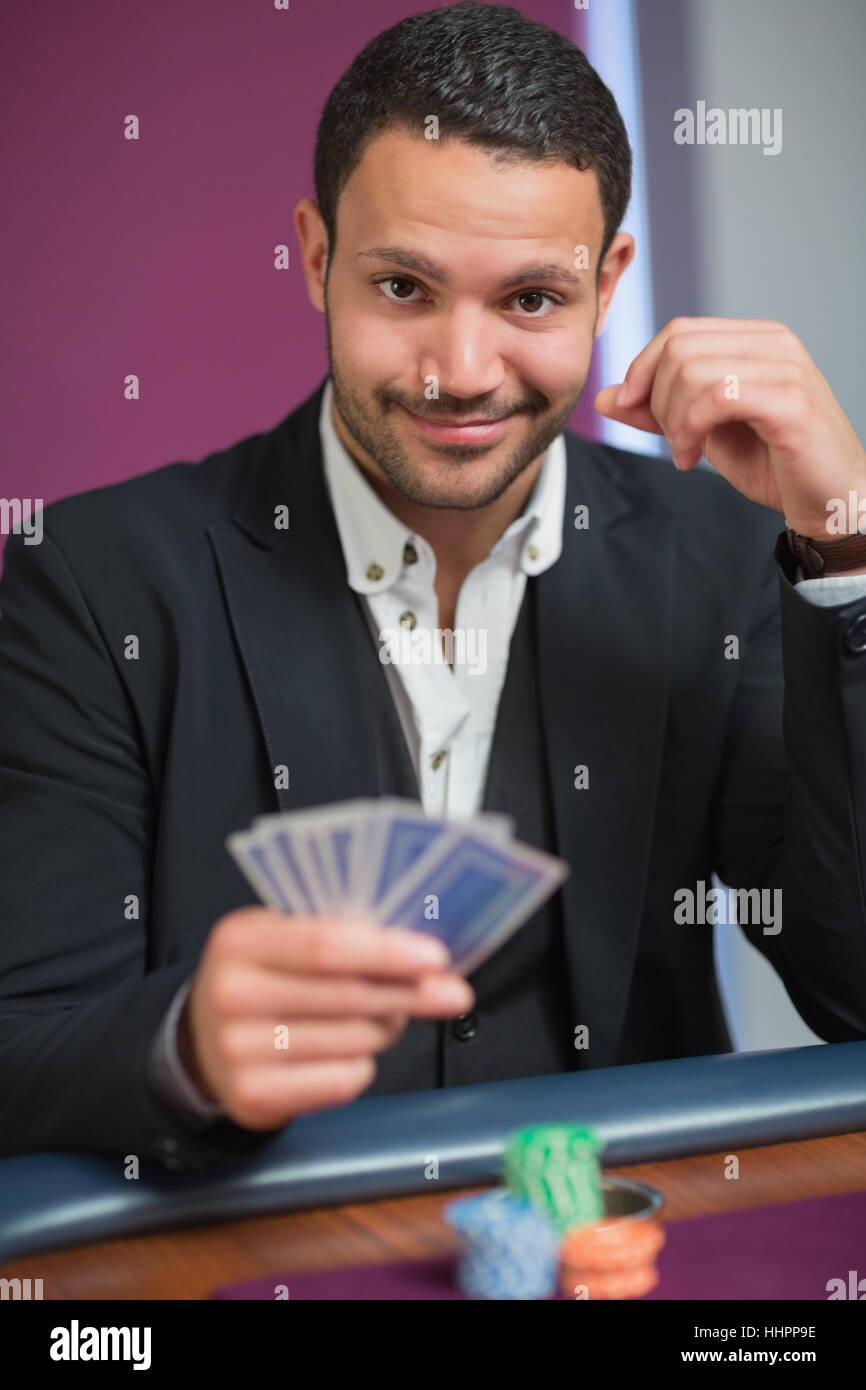 Man holding his cards looking happy Stock Photo