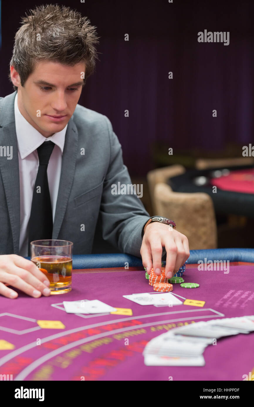 Man looking down at poker table in casino Stock Photo