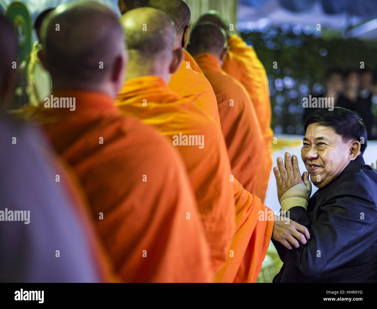 Bangkok, Thailand. 20th Jan, 2017. Pol Gen Aswin Kwanmuang, (right) the Governor of Bangkok, greets Buddhist monks filing into a merit making ceremony on the plaza in front of Bangkok's City Hall. Hundreds of municipal workers and civil servants made merit by praying and presenting alms to 89 Buddhist monks Friday to mark 100 days of mourning since the death of revered Bhumibol Adulyadej, the Late King of Thailand. The significance of 89 monks is that the King, who died on October 13, 2016, was a few weeks short of his 89th birthday. Credit: Jack Kurtz/ZUMA Wire/Alamy Live News Stock Photo