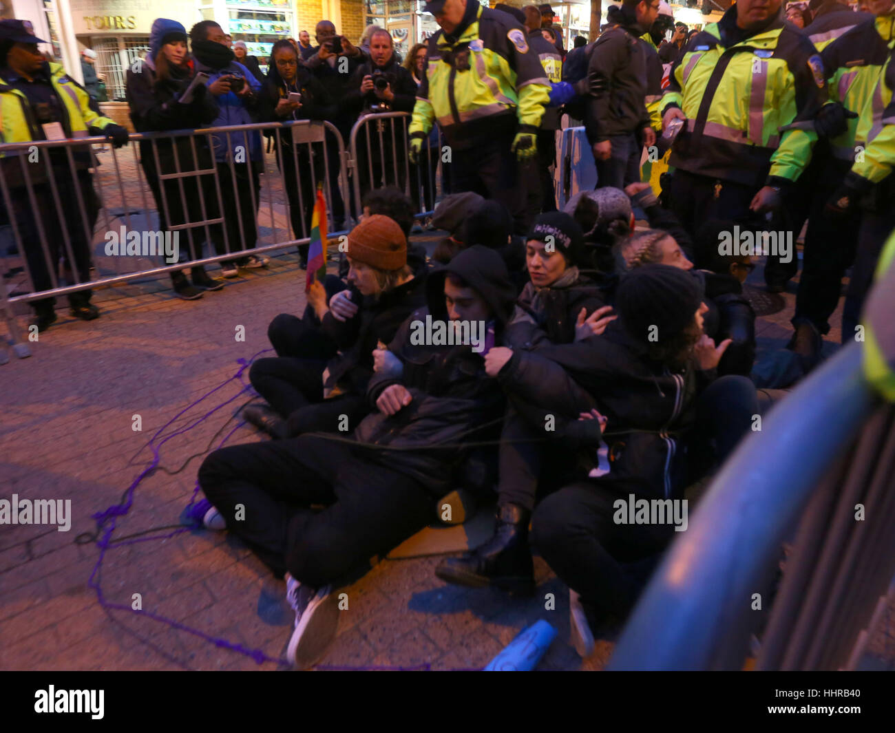 Washington DC, USA. January 20, 2017. Protesters organized under the group Code Pink use direct action techniques--locking arms---stop people from entering a security checkpoint on their way to watch the Inaugural Parade. The group was one of several simultaneous actions designed to deter access to the Inaugural Parade. Stock Photo
