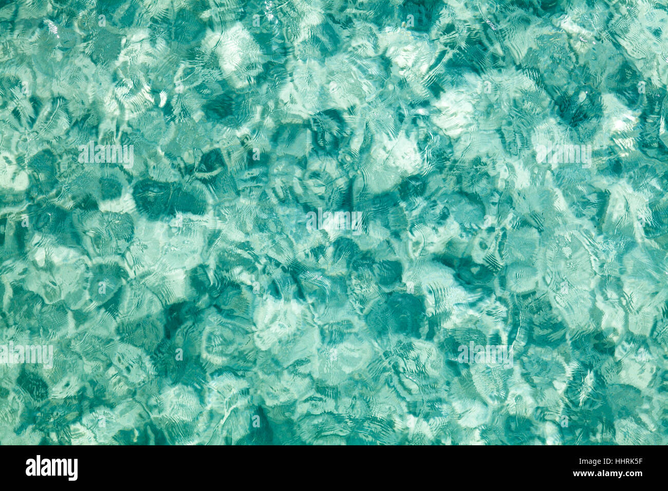 Light reflecting on clear turquoise water background. Stock Photo