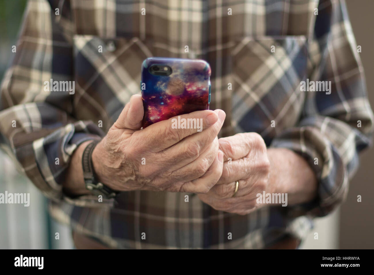 Man in Brown Plaid Shirt Holding iPhone Face On Stock Photo