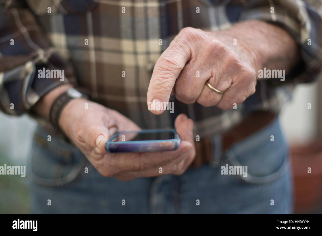 Man pointing to iPhone face on ready to enter horizontal Stock Photo