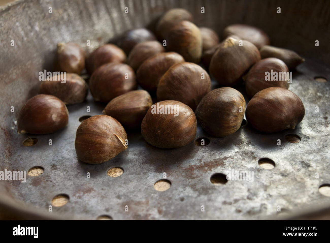 roast chestnuts in specific typical pan to roast Stock Photo Alamy
