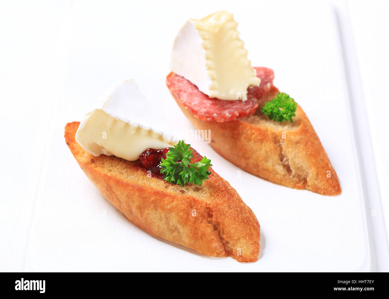 Crostini topped with white rind cheese and salami Stock Photo Alamy
