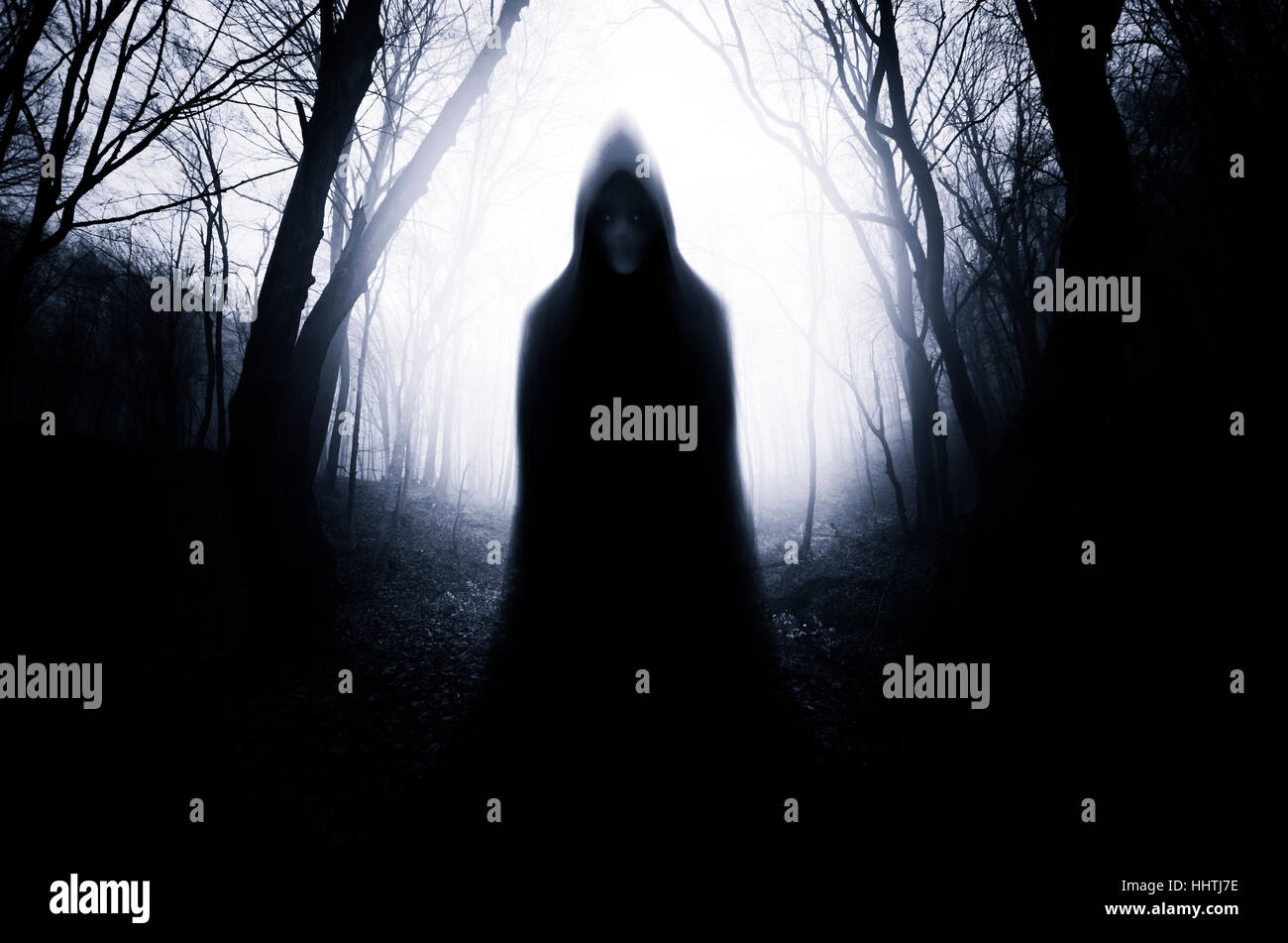 Scary ghostly figure in forest at night, gloomy Halloween scene Stock Photo