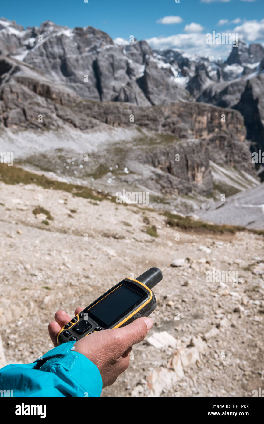 GPS navigator in hand against Dolomites Alps Stock Photo