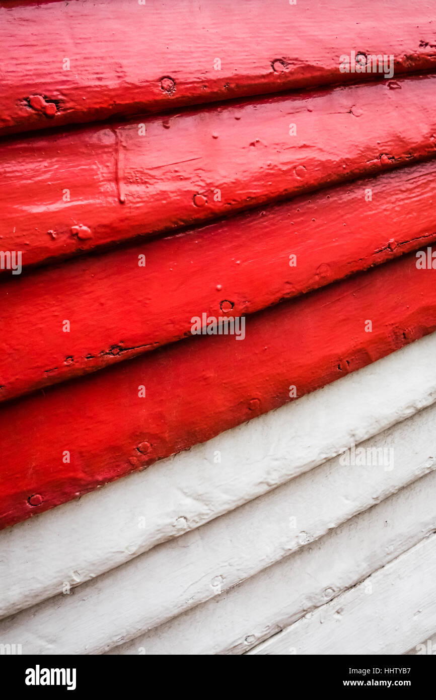 Red and white rows of painted wooden side of a fishermen boat Stock Photo