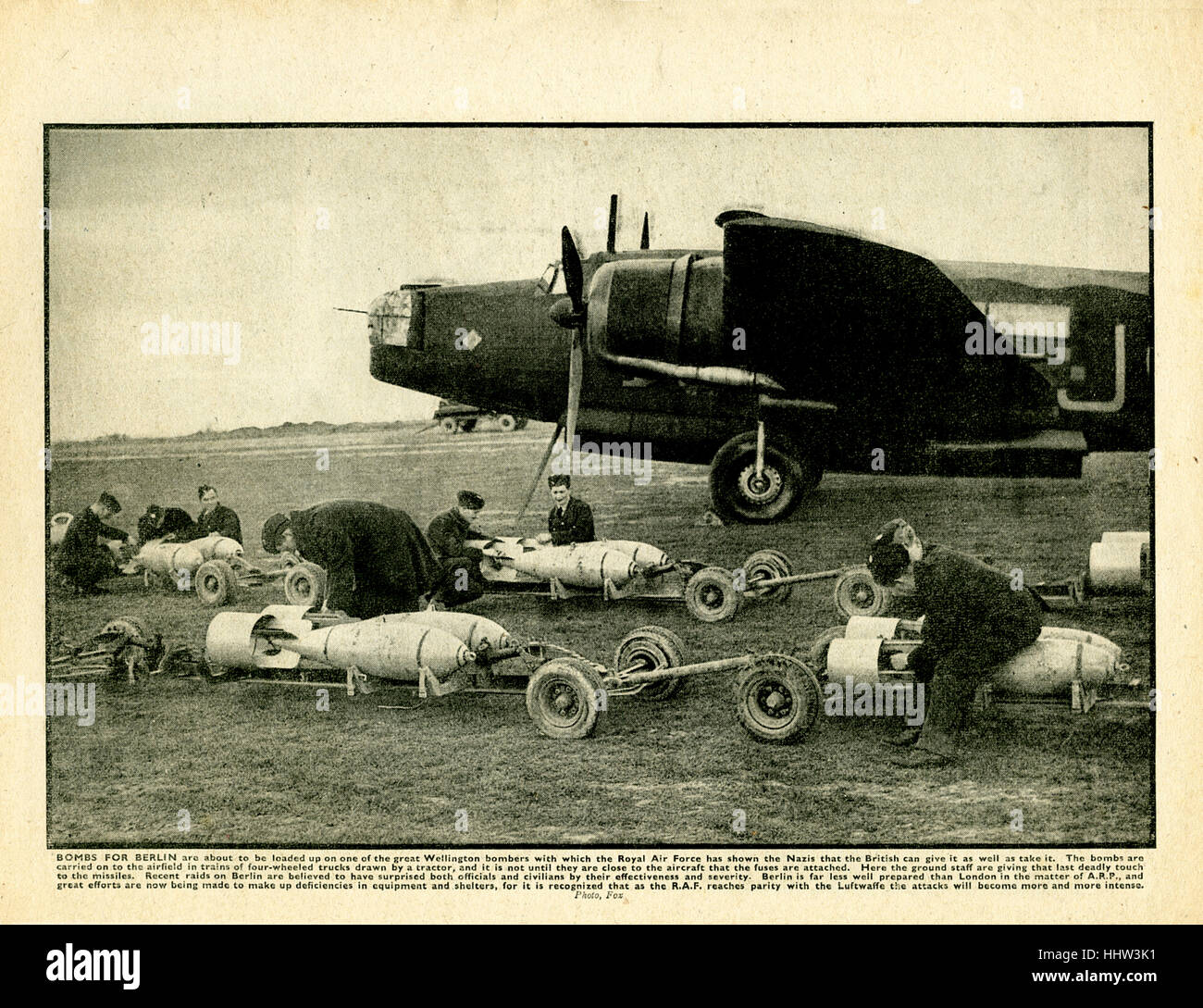 Bombs for Berlin are about to be loaded up on one of the great Wellington bombers with which the royal Air Force has shown the Nazis that the British can give it as well as take it…. Here the ground staff are giving that last deadly touch to the missiles. Recent raids on Berlin are believed to have surprised both officials and civilians by their effectiveness and severity.' Caption in The War. Stock Photo