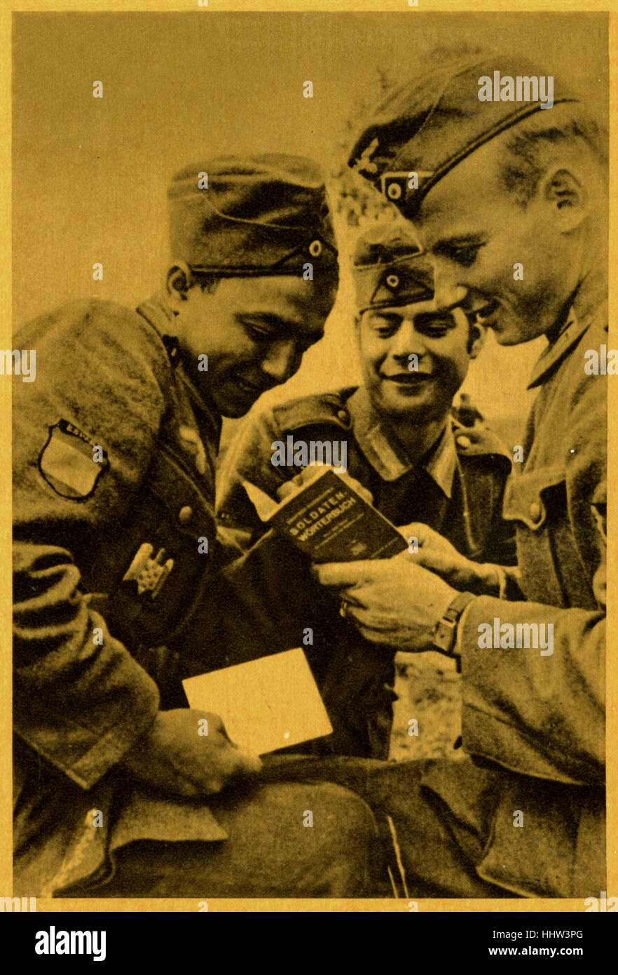 Spanish-German comradership at the front:  reading a German soldiers dictionary during World War 2. Original caption in Spanish Stock Photo