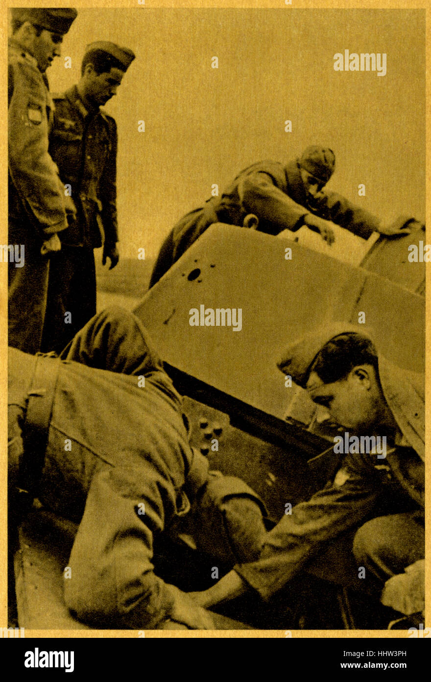 Inspection of a captured Soviet tank . Original caption in Spanish: Inspección de un tanque soviético apresado). From series of cards called 'The European Crusade against Bolshevism: The Blue Brigade' (picture 6) / La cruzada europea contra el bolchevismo. La División Azul. La División Azul was unit of Spanish and Portuguese volunteers that served in the German Army on the Eastern Front of the Second World War. Stock Photo