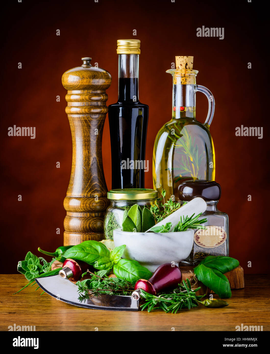 Green Basil and Sage with herbs chopper and bottles of Balsamic vinegar with virgin olive oil Stock Photo
