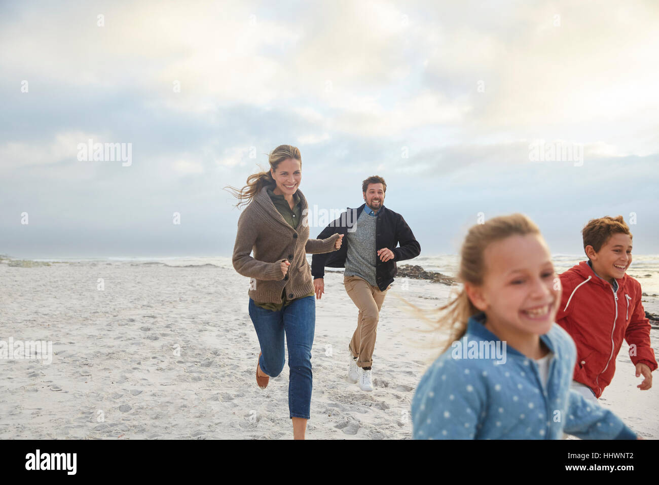 Happy family running on beach hi-res stock photography and images - Alamy