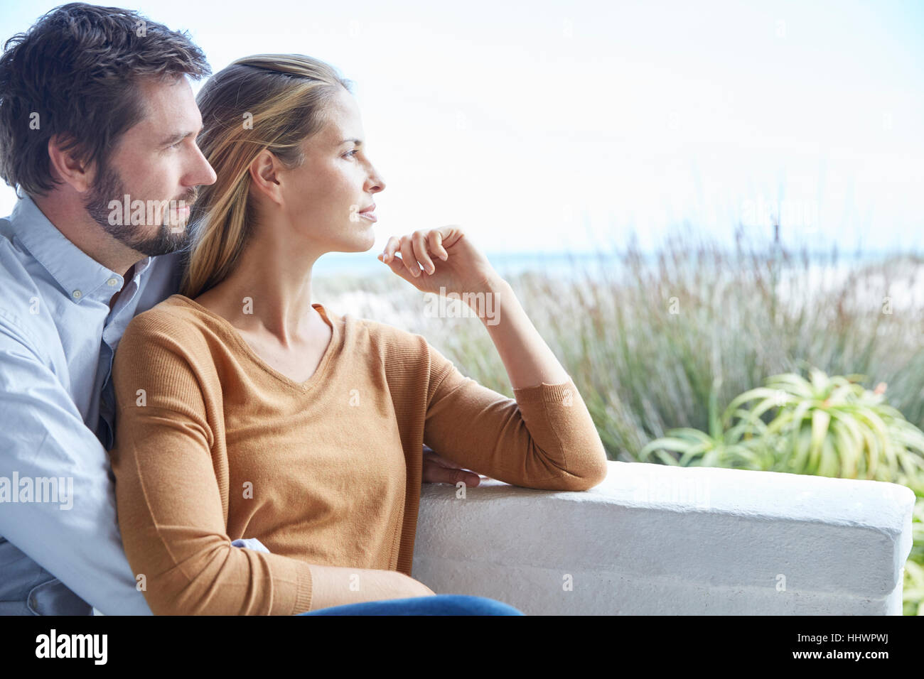 Serene couple looking away on patio Stock Photo