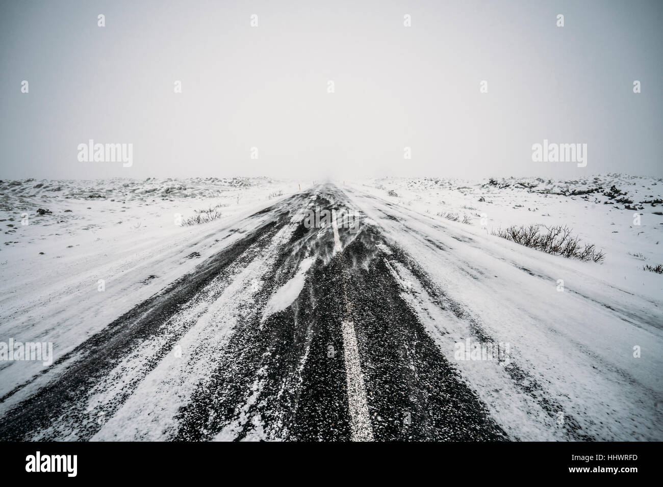 Diminishing perspective remote snow covered road Stock Photo