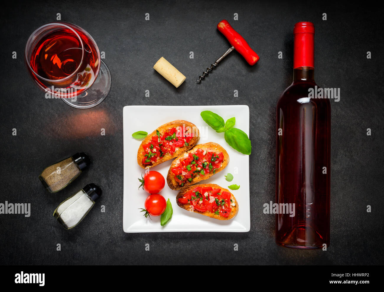 Italian Cuisine Bruschetta with Tomao, Basil and Rose Wine Glass and Bottle Stock Photo