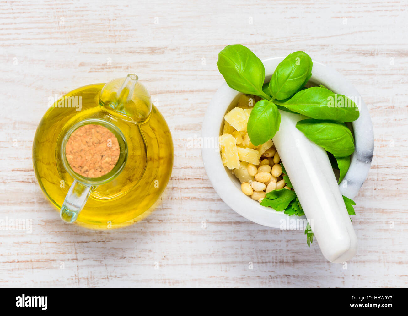 Top View of Olive Oil and Pestle and Mortar with Basil, Cheese and Pine Nuts Stock Photo