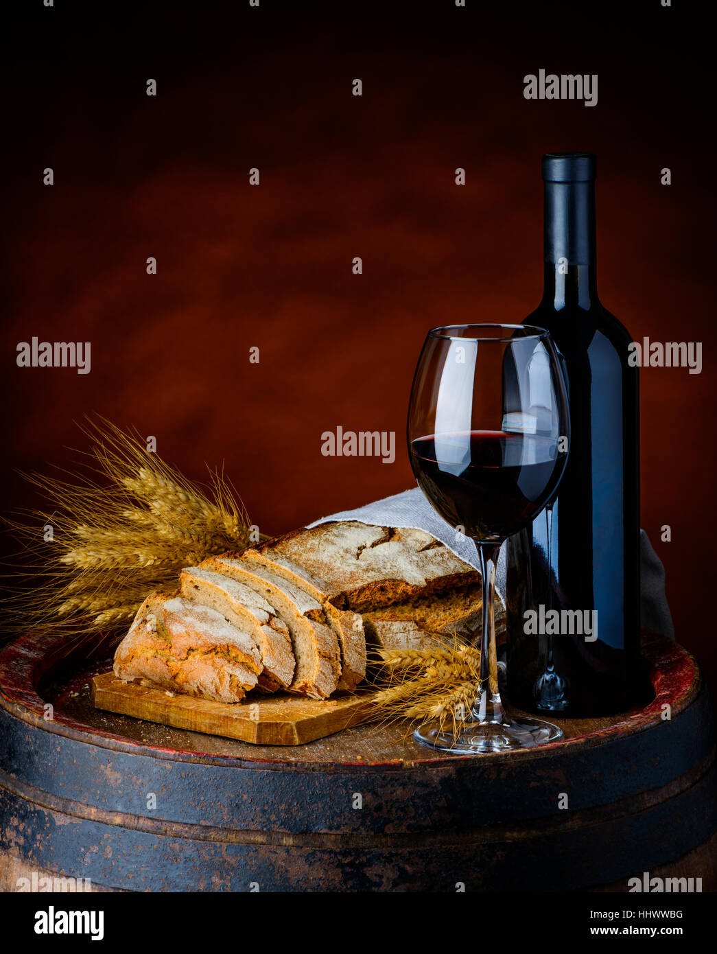 red wine, sliced bread and whteat in a rustic setup Stock Photo