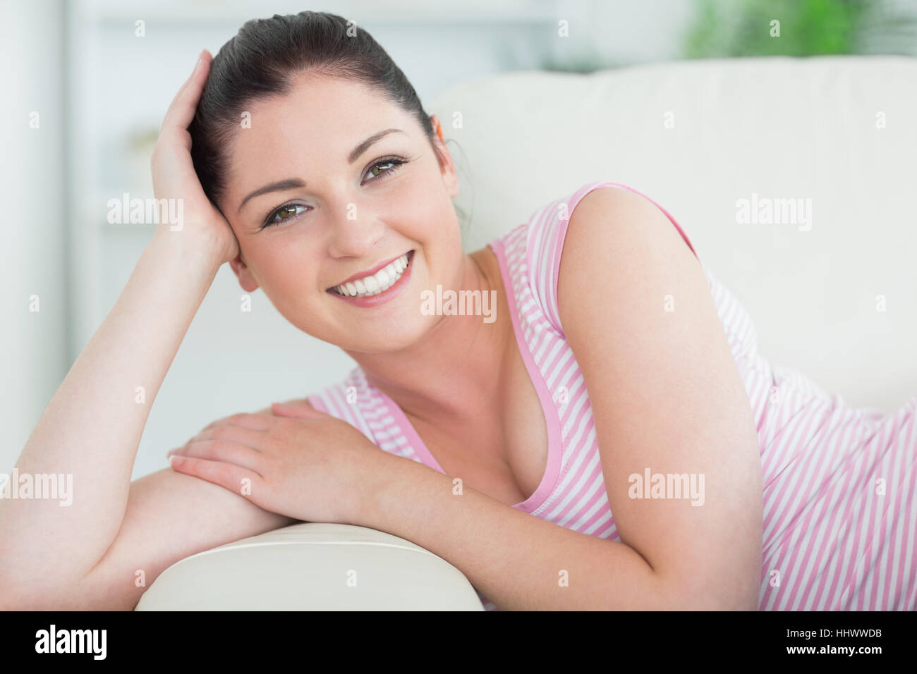 Cheerful woman lying and relaxing on the couch in the living room Stock ...