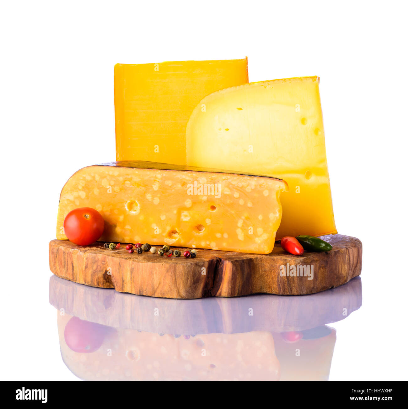 Hard cheese, colby, gouda, and swisscheese on wooden chopping board with pepper Stock Photo Alamy