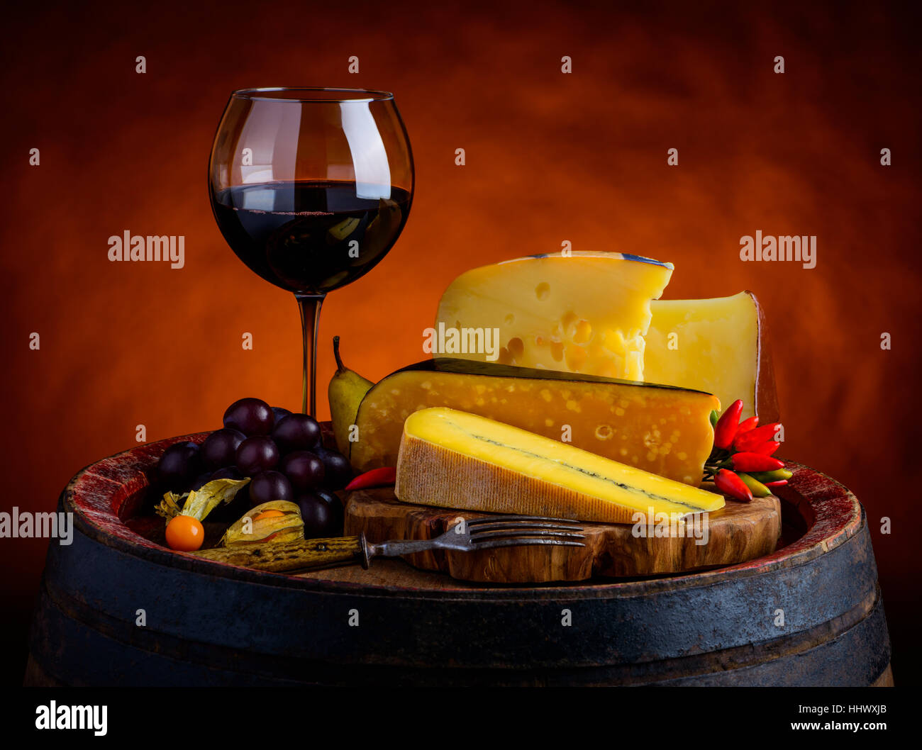 Morbier, emmentaler swiss cheese and gouda with glass red wine in