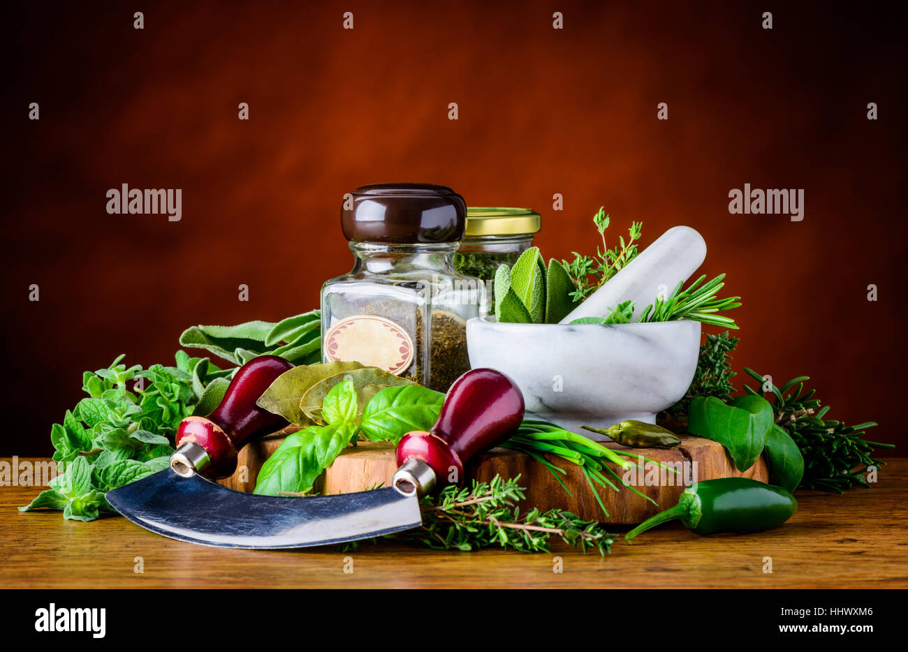 Green Cooking Herbs basil, rosemary, dill, sage with mezaluna herbs chopper and pestle & mortar Stock Photo