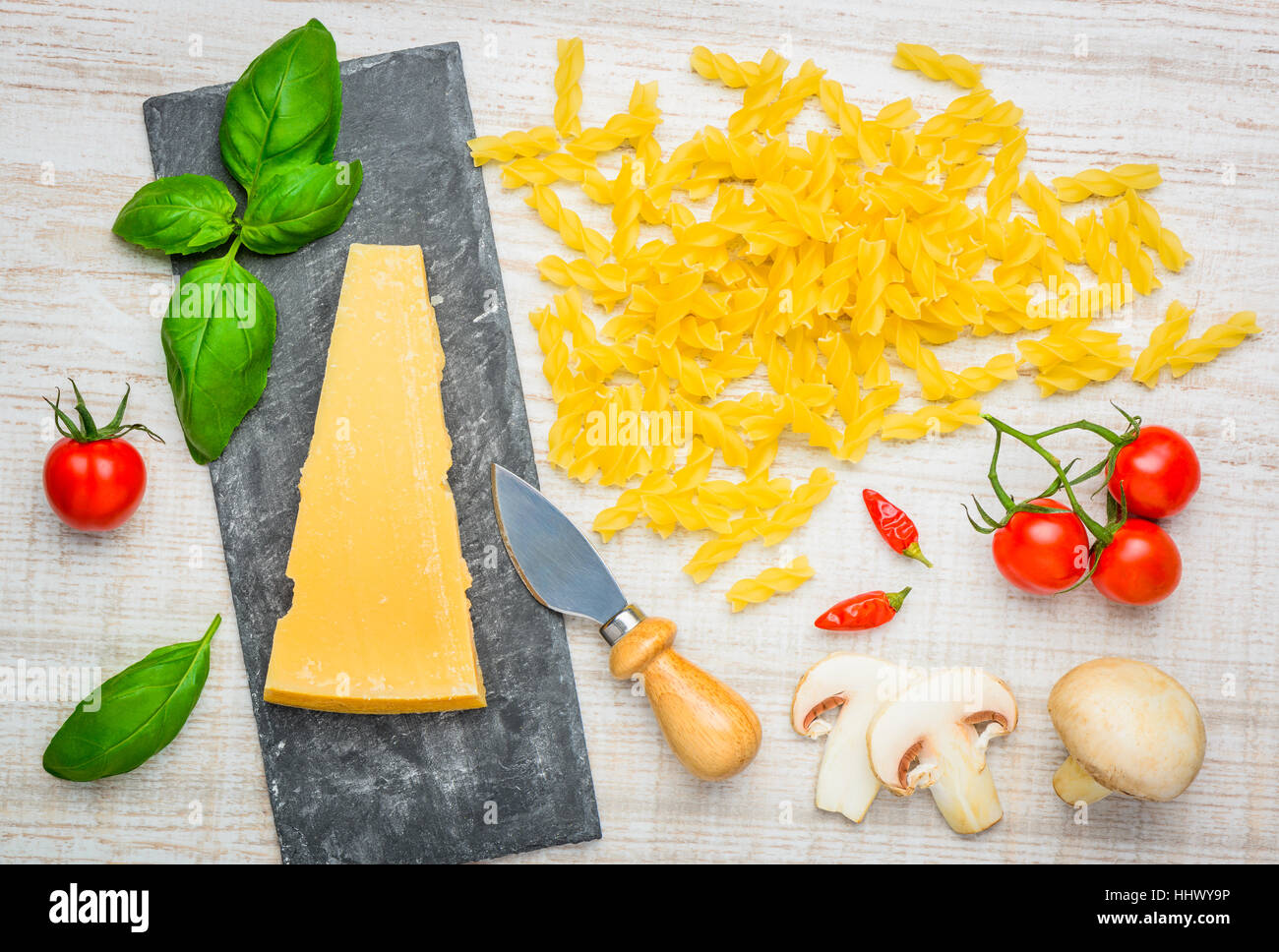 Yellow Fusilli Pasta with Parmesan cheese and basil, tomato and mushrooms Stock Photo