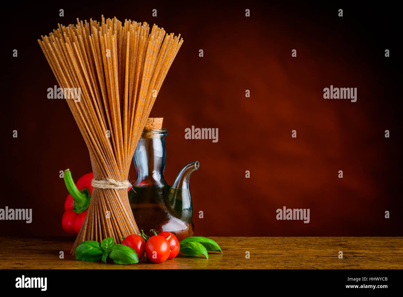 Brown Spaghetti Pasta with Pepper and Oil and Basil on Copy Space Stock Photo