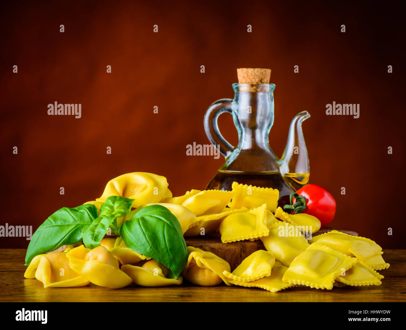 Yellow Ravioli and Tortellini Pasta and Olive oil with Basil and Tomato Stock Photo