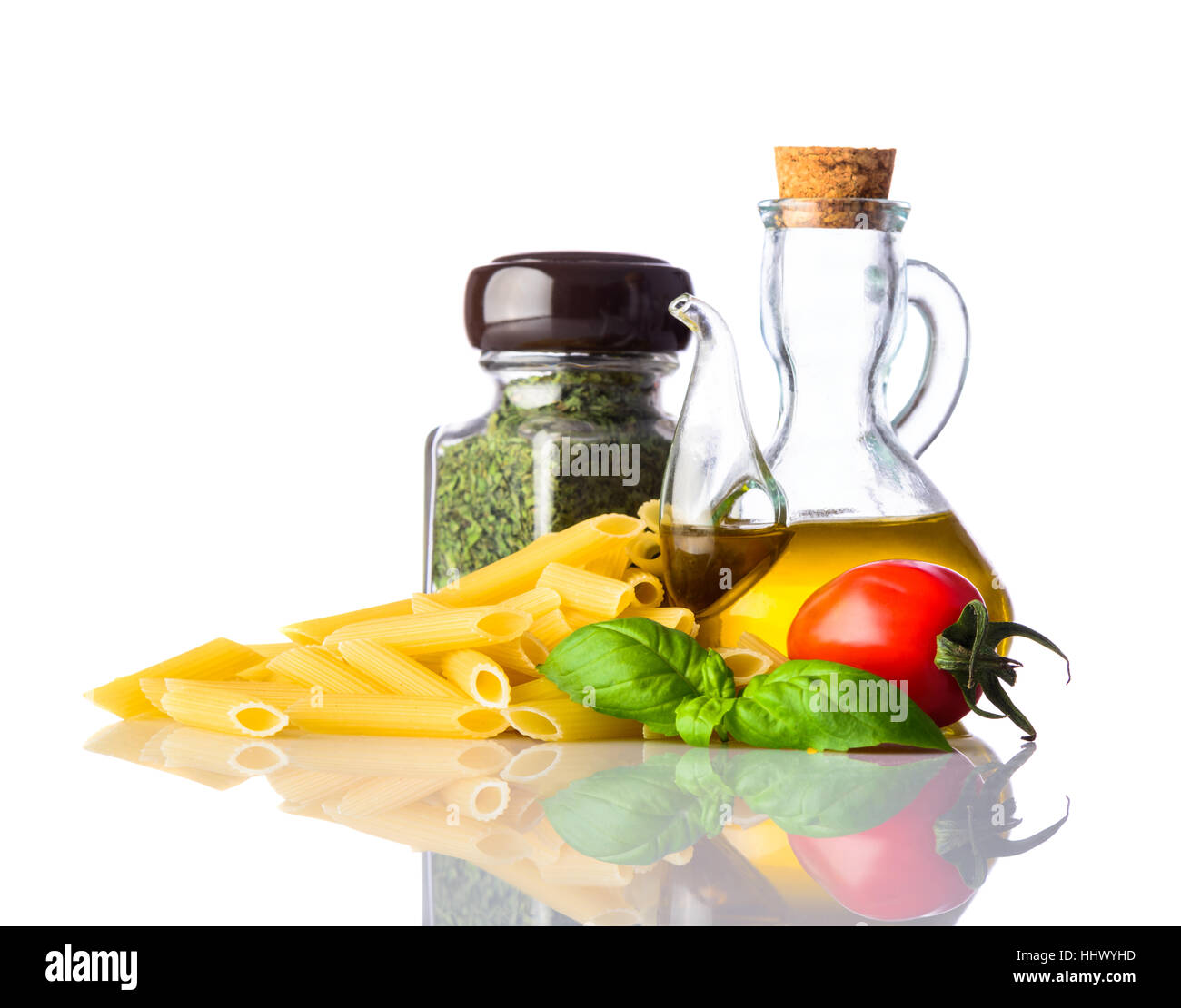 Yellow Penne with Seasoning and cooking herbs. Basil and tomato as Italian or mediterranean cuisine food isolated on white background Stock Photo