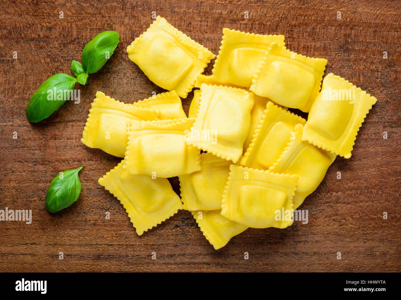 Yellow ravioli pasta with green basil, italian cuisine food Stock Photo