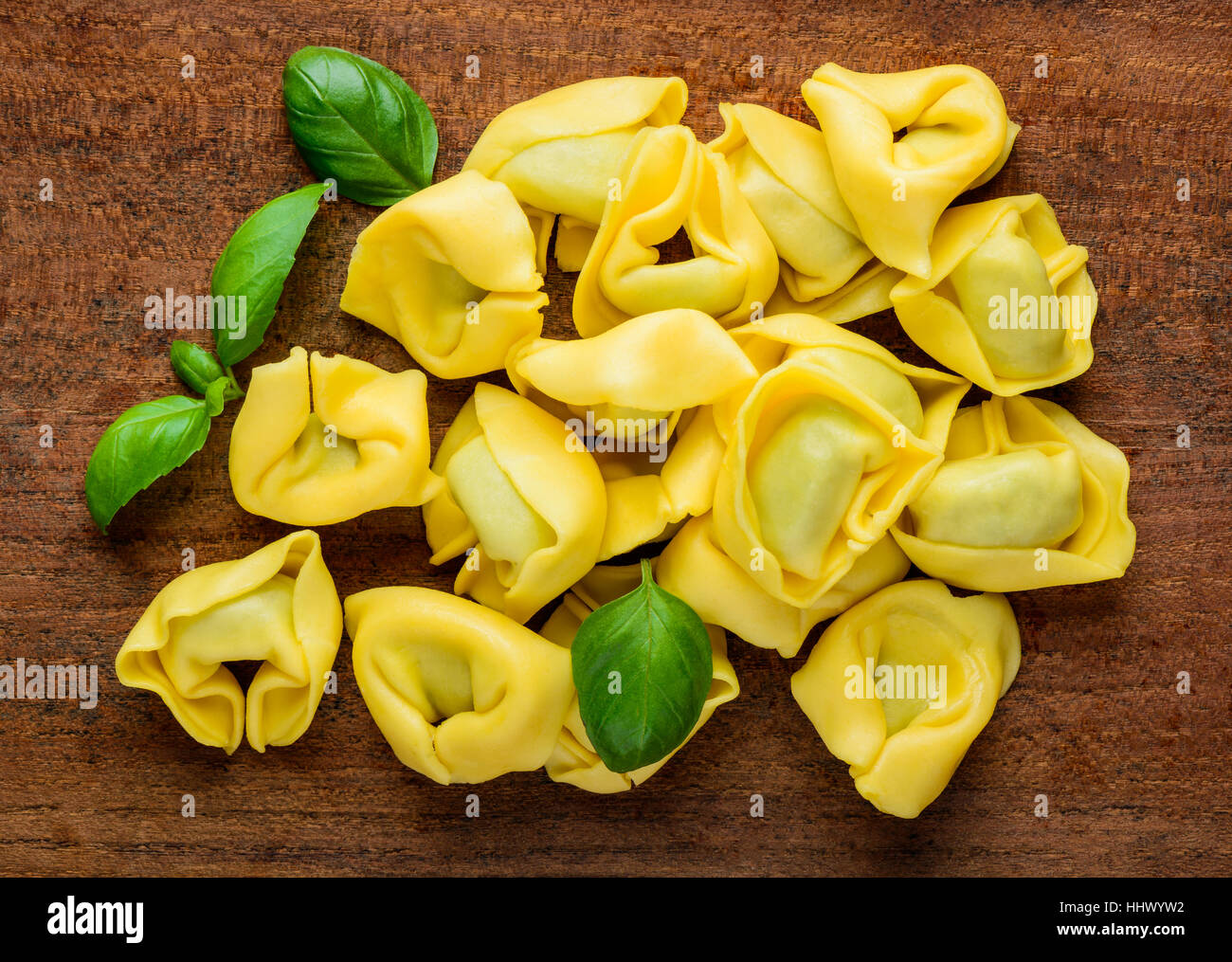 Yellow Tortelini Pasta with green Basil leaves Stock Photo