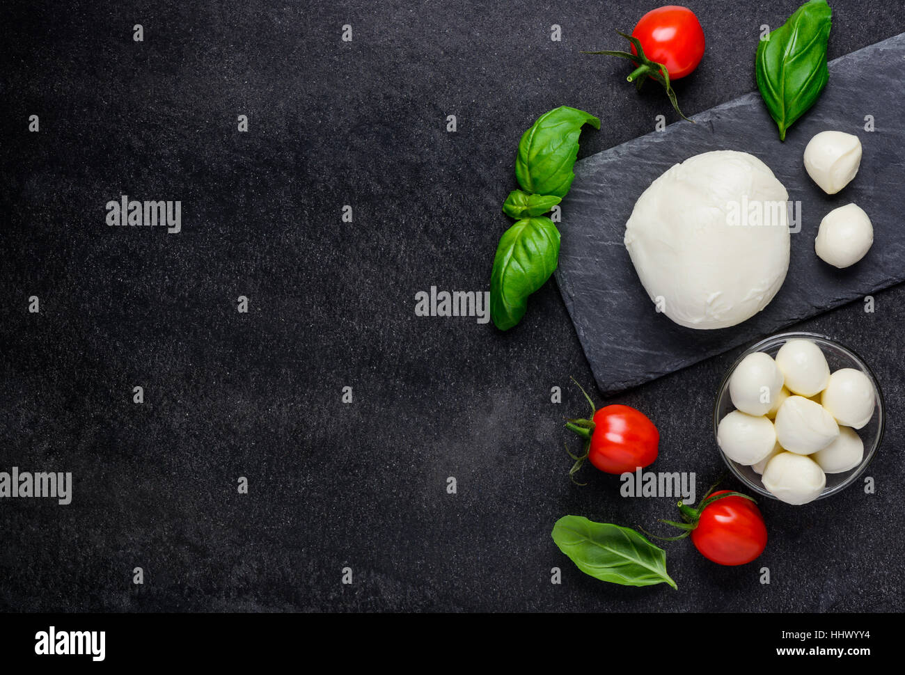 Italian Mozzarella cheese balls and fresh tomato and basil with copy space Stock Photo