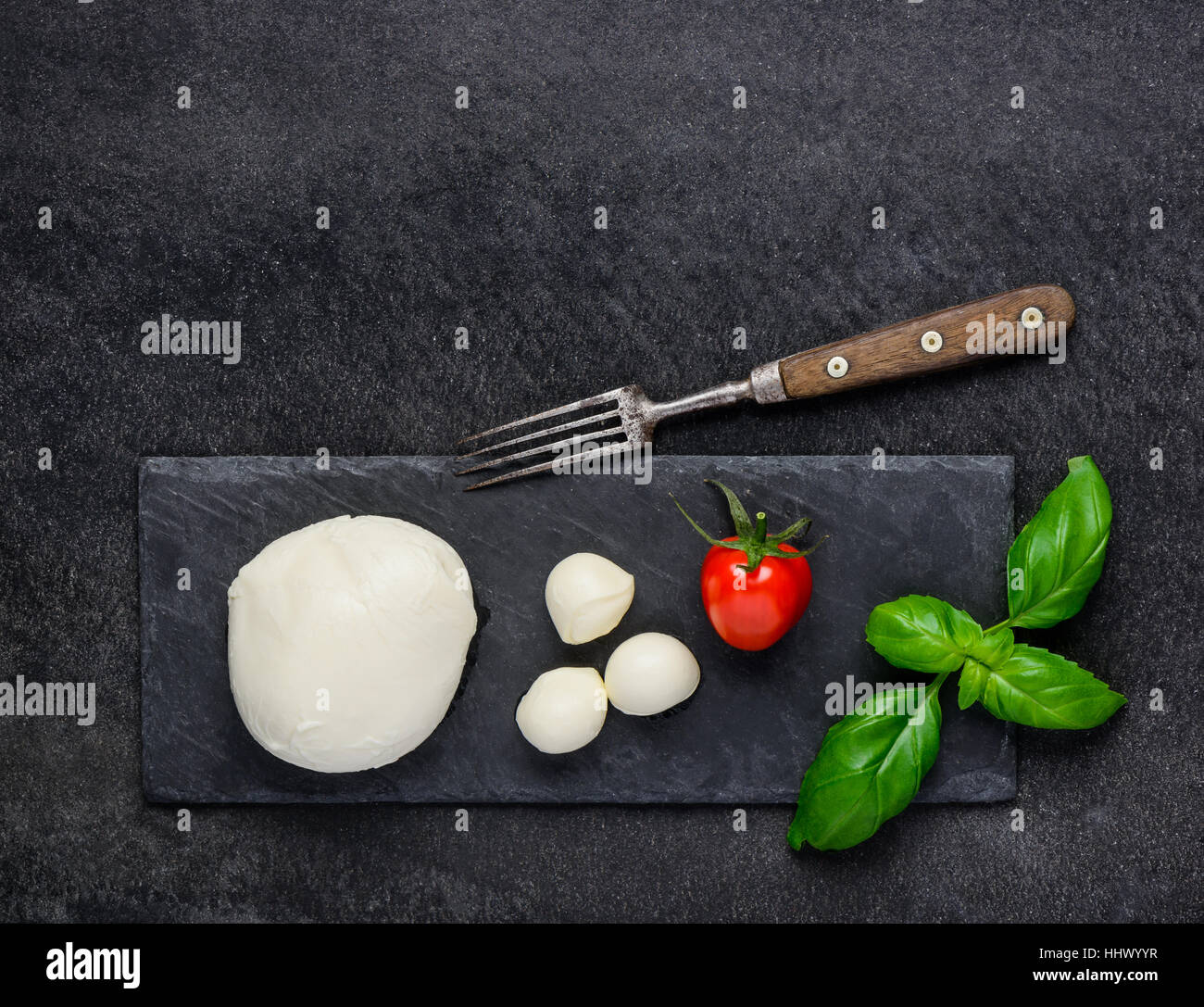 Fresh juicy italian mozzarella cheese balls with tomato and basil on copy space Stock Photo