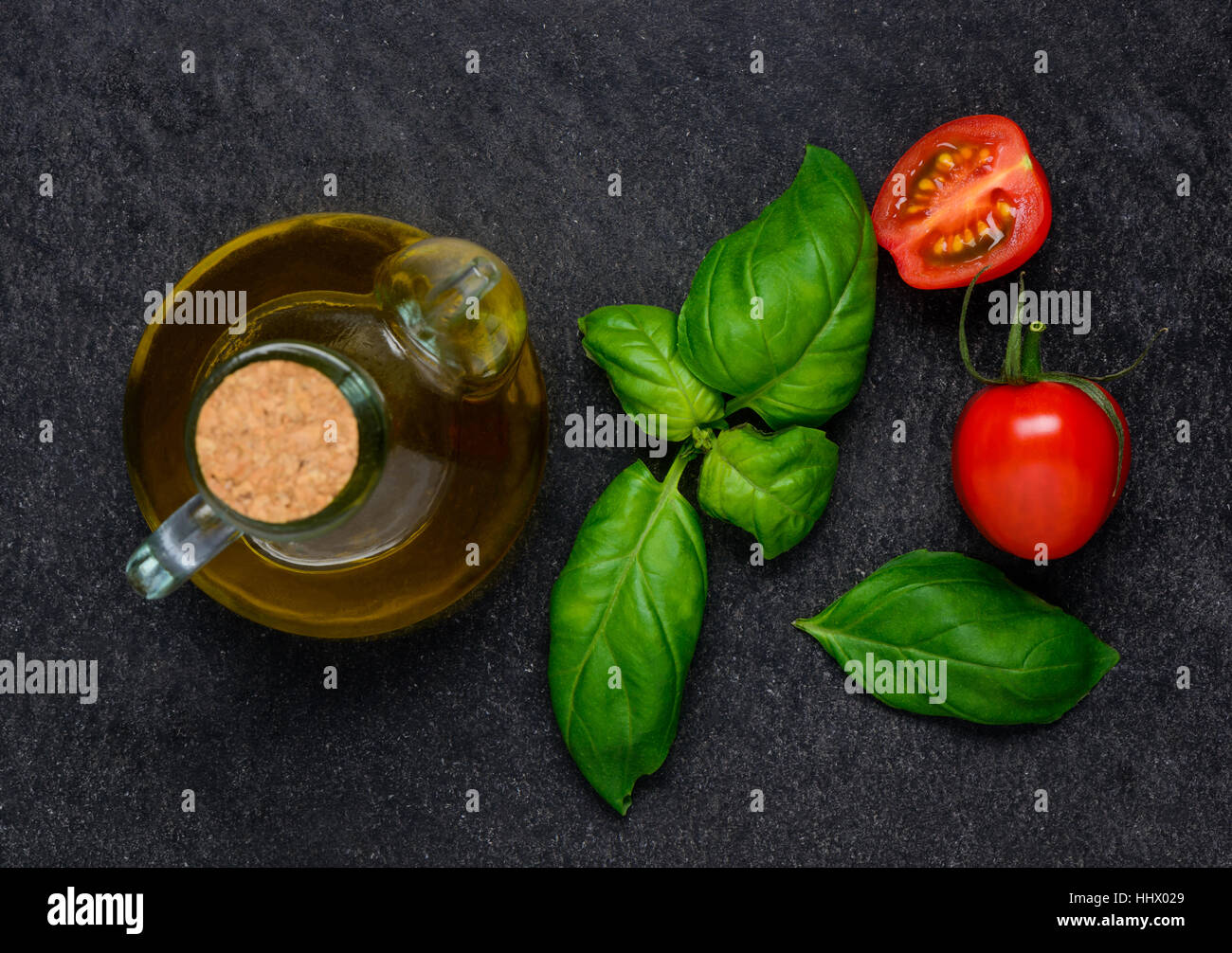 Bottle of olive oil and Fresh green basil leaves with red tomato Stock Photo