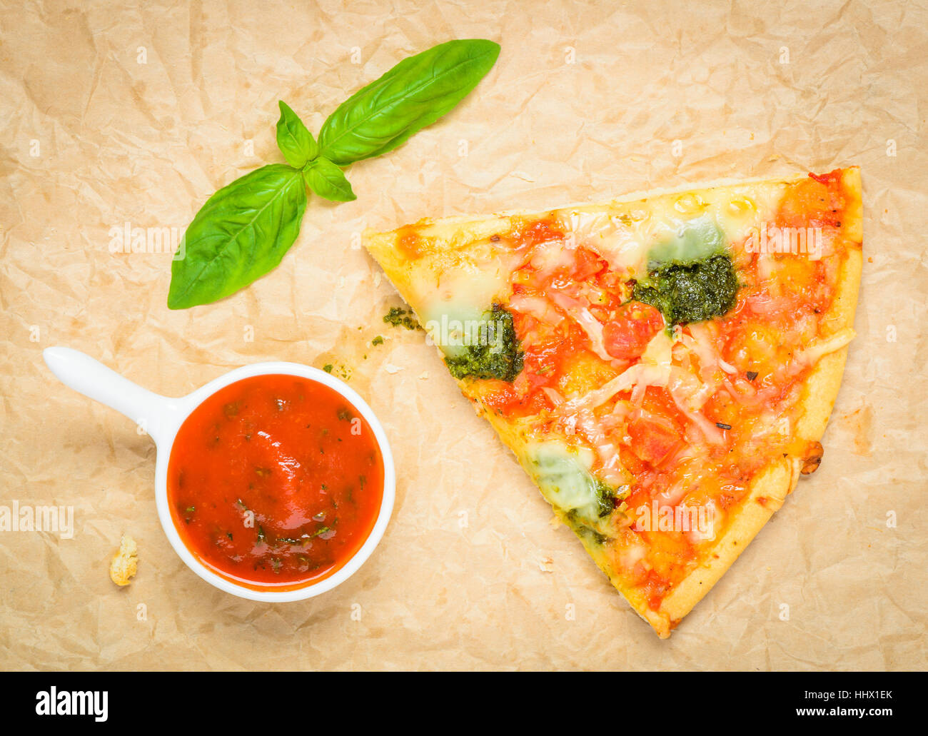 Italian Baked Pizza slice with Tomato Sauce and Fresh green leave of Basil Stock Photo
